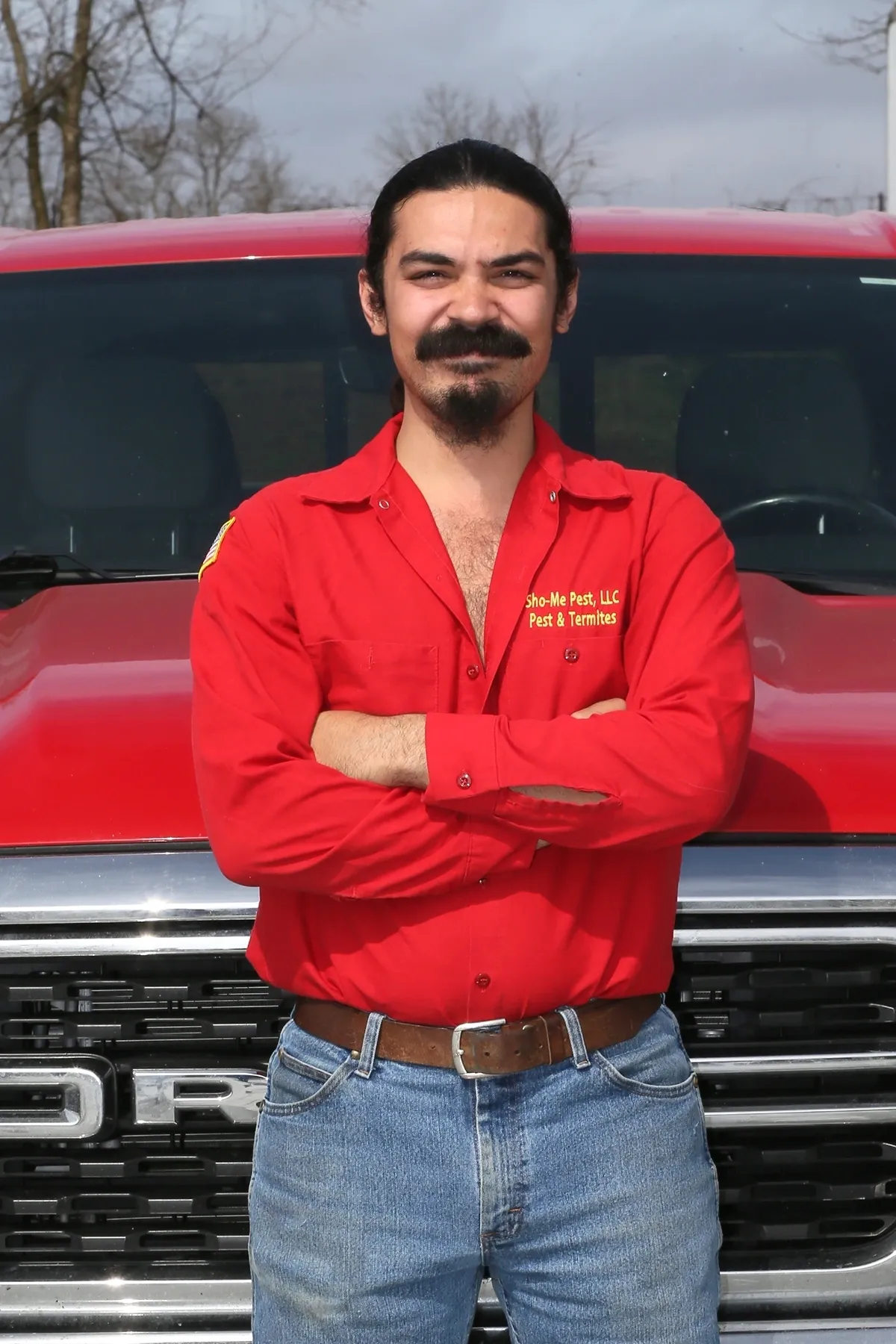Man in red shirt standing by truck.