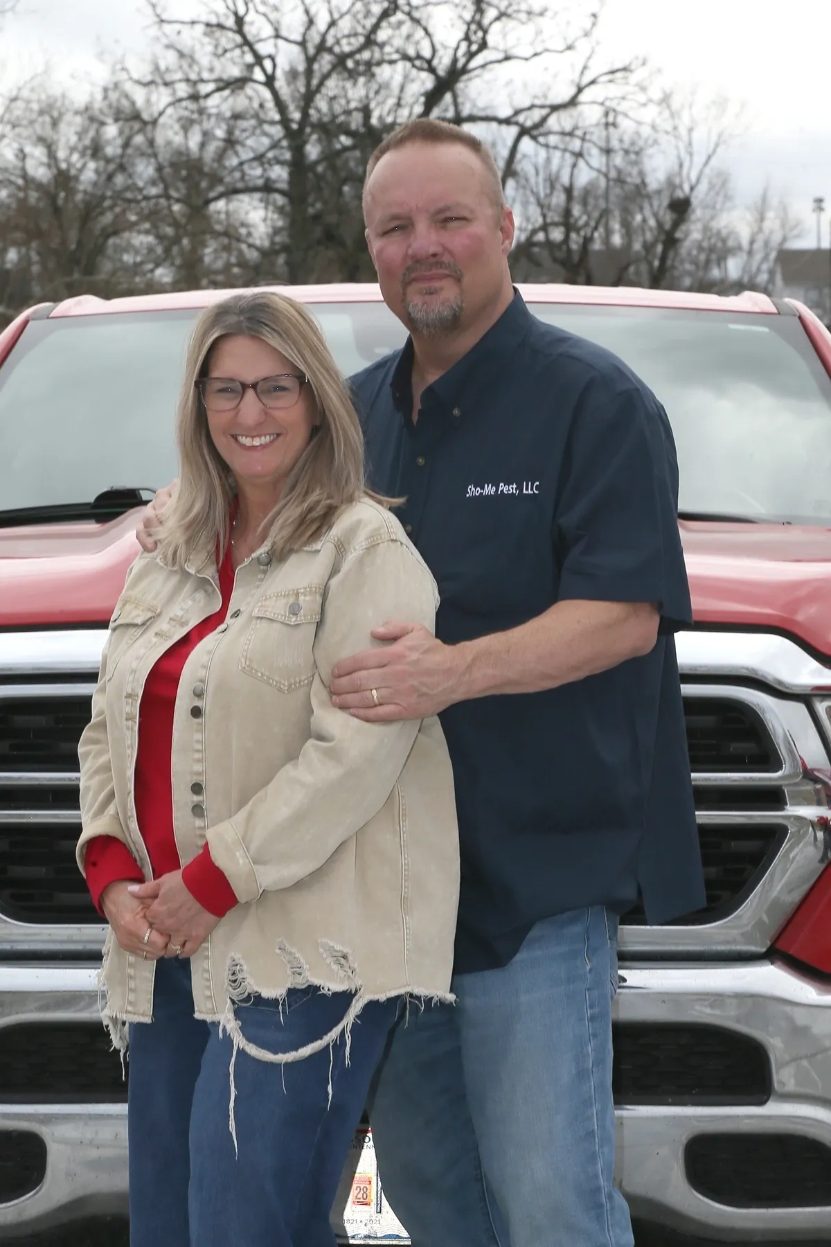 Couple standing in front of red truck.