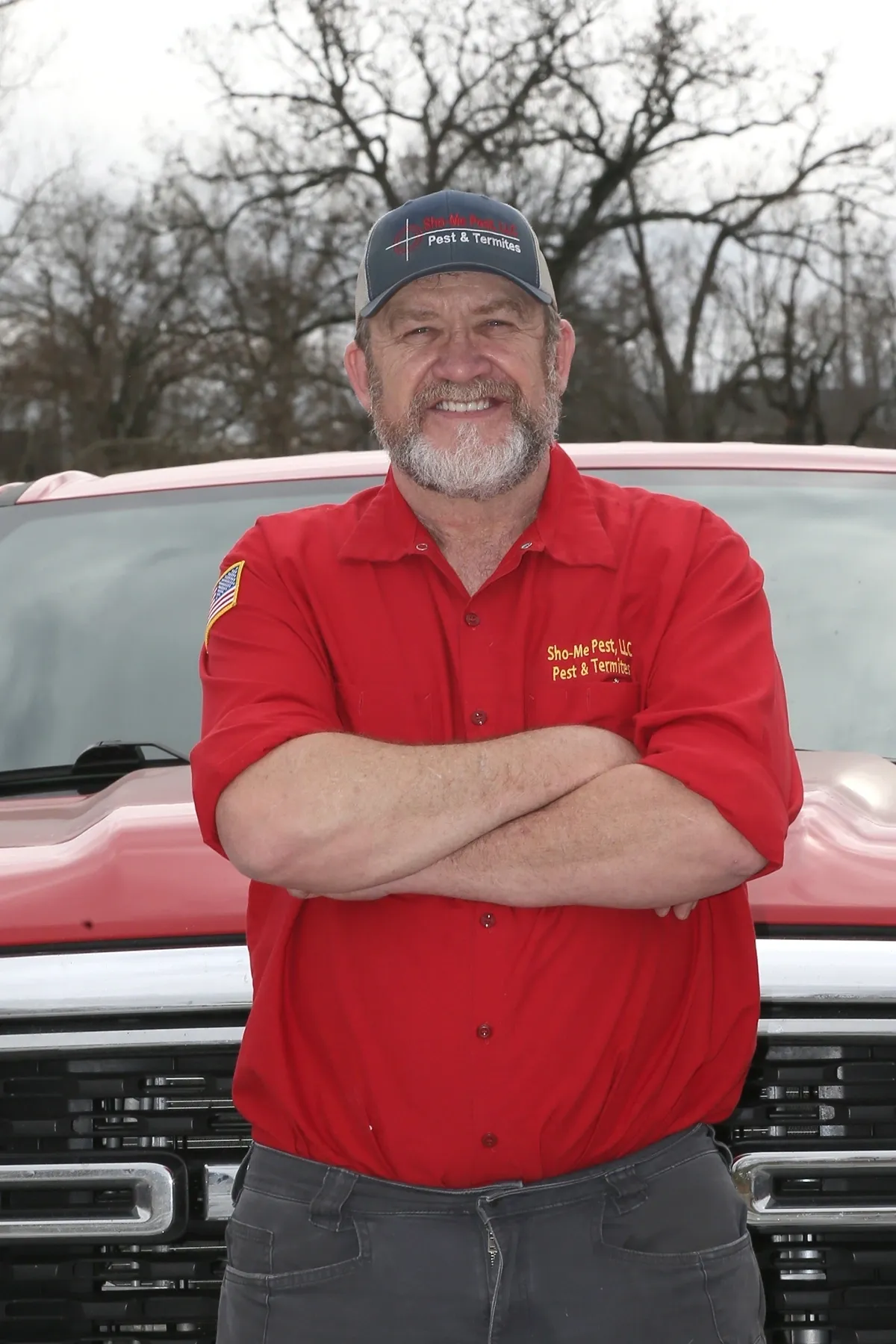 Man in red shirt standing by truck.