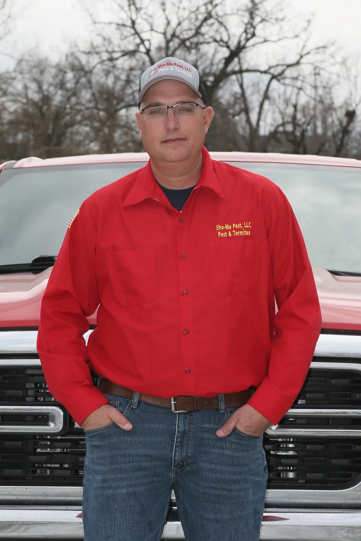 Man in red shirt standing by truck.